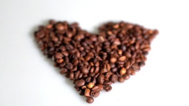 kahve çekirdekleri beyaz bir arka planda kalp şeklinde toplanır