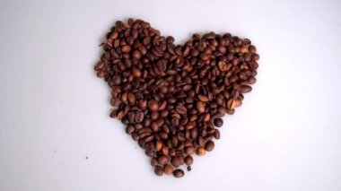 kahve çekirdekleri beyaz bir arka planda kalp şeklinde toplanır