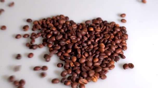咖啡豆被收集在一个心脏在白色背景的形状 — 图库视频影像