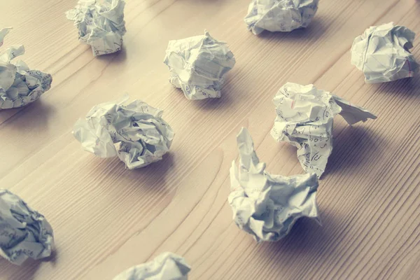 Many crumpled white paper balls on wooden table. Texture of crumpled paper balls.  Crumpled paper as brainstorming, creativity concept, mistakes and creation symbol. toned