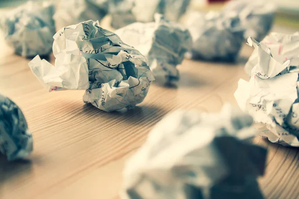 Many crumpled white paper balls on wooden table. Texture of crumpled paper balls.  Crumpled paper as brainstorming, creativity concept, mistakes and creation symbol. toned