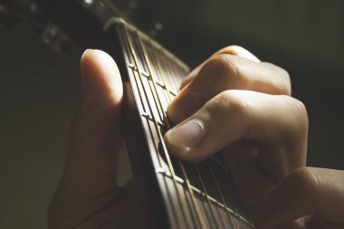 Akustik gitar dizeleri üzerinde Man's hands parmakları güneş parlaklık makro çekim kapatın. Müzik, hobi 