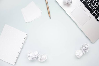 İş ve yaratıcılık kavramı. Dizüstü bilgisayar, not defteri, buruşturulmuş kağıt topları ve kalem üst görünüm düz copyspace ile fotoğraf yatıyordu. Bilgisayar ve kağıt işleri. Yukarıdaki Ofis