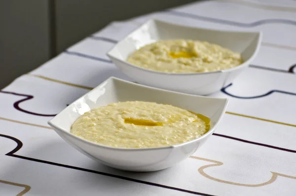 Darı lapası ve tereyağı biraz ile beyaz bir kare kase. Tahıl bu tür popüler kahvaltı yemektir Rusya ve Doğu Avrupa.