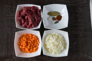 Doğranmış Dana eti, havuç, soğan ve yemek pişirmek için hazırlanan bazı baharat (tuz, biber, kırmızı biber ve defne yaprağı) 
