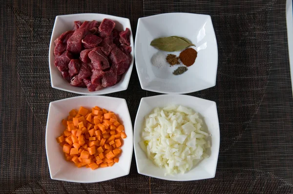 Doğranmış Dana eti, havuç, soğan ve yemek pişirmek için hazırlanan bazı baharat (tuz, biber, kırmızı biber ve defne yaprağı) 