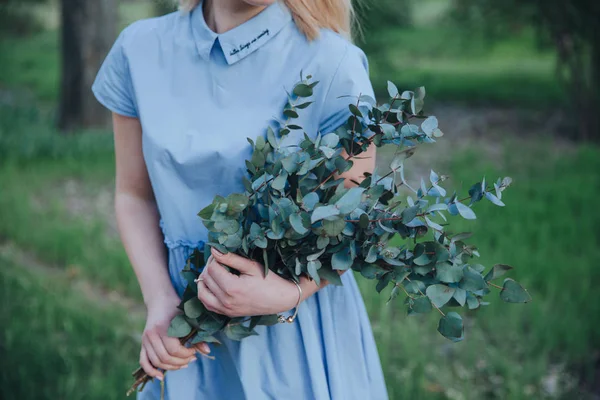 a girl in blue dress with the rustic bouquet in her hands