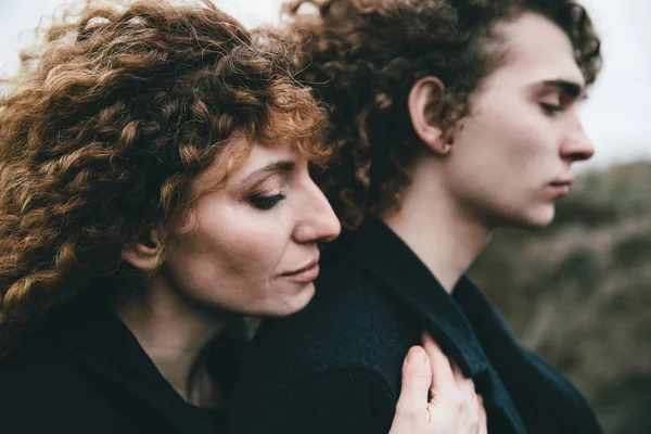 Yetişkin oğlu ve kıvırcık saçlı anne sarılma 