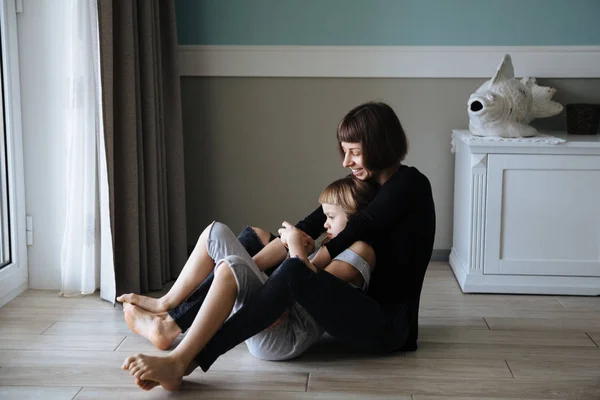 Νεαρή Μητέρα Αγκαλιάζει Προσχολικής Ηλικίας Κόρη Στο Πάτωμα — Φωτογραφία Αρχείου