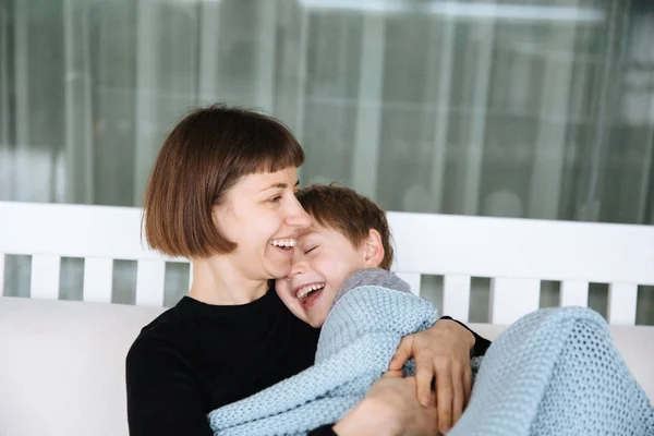 mutlu anne battaniye ye sarılmış oğlu ve kanepeye sarılma