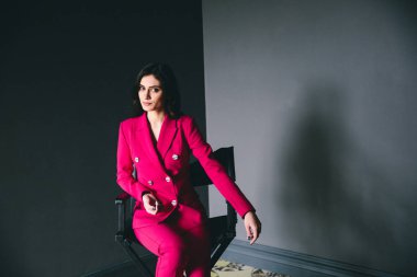 gri duvarlar ile karanlık odada poz pembe elbiseli genç şık kadın