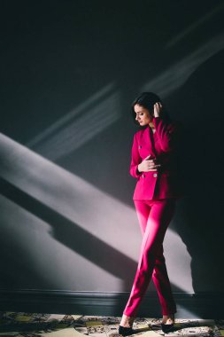 gri duvarlar ile karanlık odada poz pembe elbiseli genç şık kadın