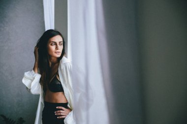 genç kadın evde pencerede poz