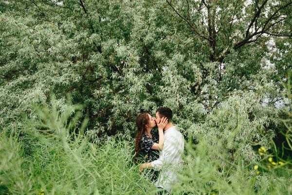 young couple in green field on summer day