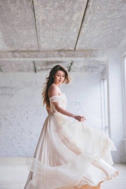 Gelinlik giymiş genç şık bir gelin eski duvar arkasında