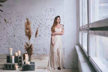 Gelinlik giymiş genç şık bir gelin eski duvar arkasında