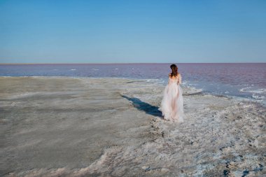 Sahilde düğün elbise gelin dokunmadan. Arkadan görünüm.