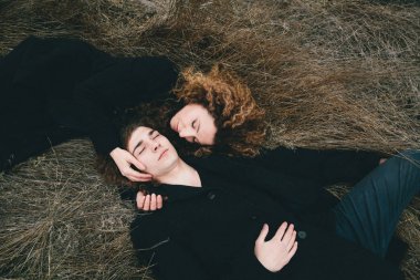 Yetişkin oğlu ve saman sahada döşeme kıvırcık saçlı anne.