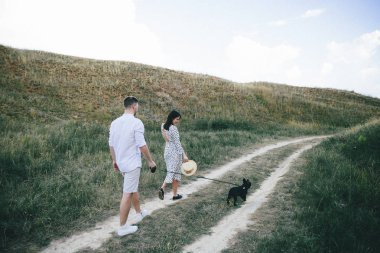 Alanda yürüyen genç hamile çiftin dış portresi