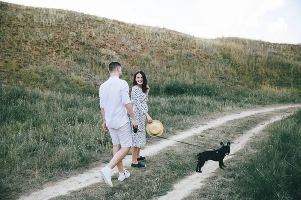 Retrato al aire libre de caminar joven pareja embarazada en el campo —  Fotos de Stock