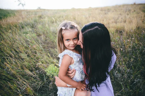 Mutter und Tochter entspannen sich zur Frühlingszeit im Weizenfeld. — Stockfoto