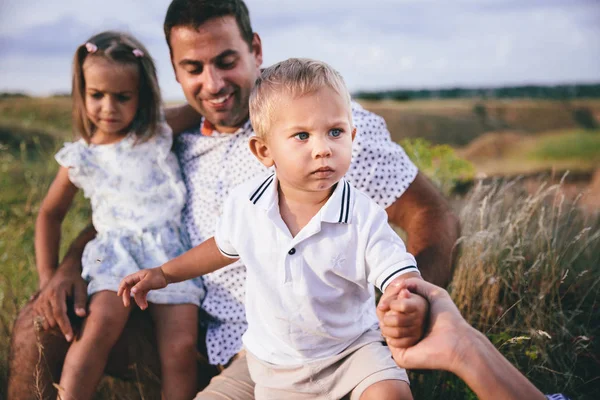 Gelukkige vader en kinderen plezier buitenshuis in een tarwe veld. — Stockfoto