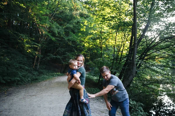 Family having fun and walking on the bank of the river — Stock Photo, Image