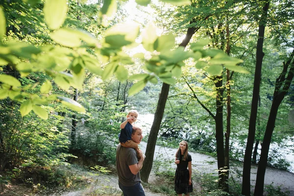 Family walking on the bank of the river — Stock Photo, Image