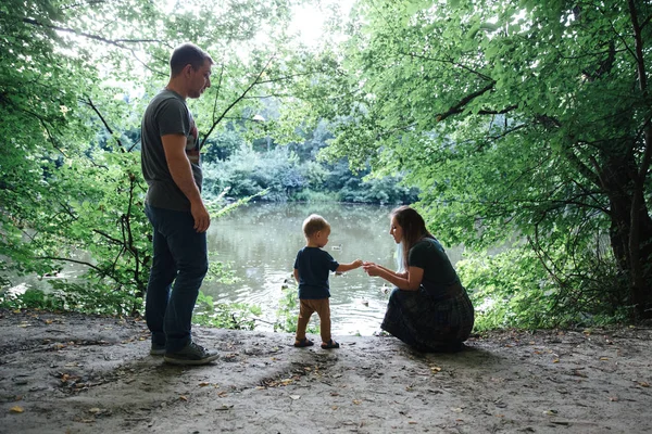Family together on the bank of the river — Stock Photo, Image