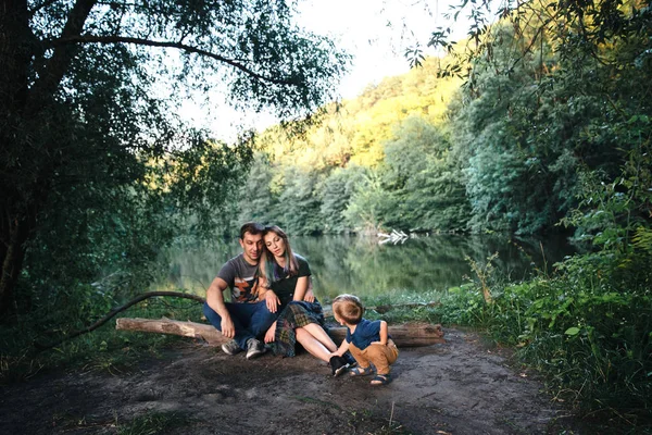 Happy joyful young family father, mother and little son outdoors, hugging together in summer park — Stock Photo, Image