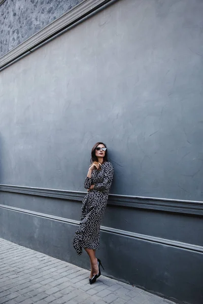 Fashionable woman wearing a black polka dot designer dress. ideal summer outfit. european fashion blogger streetstyle. — Stock Photo, Image