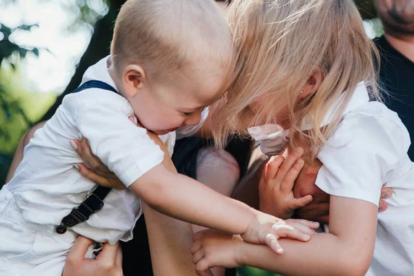 Geschwisterpaar in weißen Kleidern spielt mit Papa und Mama im Park oder Garten — Stockfoto