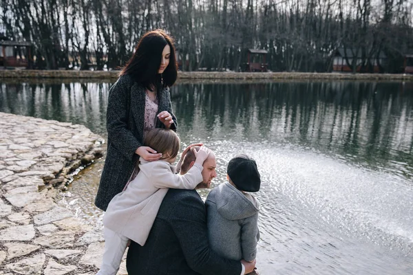 Feliz hermosa familia divirtiéndose y caminando por el lago en el día de otoño . —  Fotos de Stock