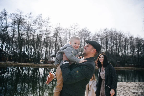 ครอบครัวที่สวยงามมีความสุข มีความสนุกสนานและเดินริมทะเลสาบในวันฤดูใบไม้ร่วง . — ภาพถ่ายสต็อก