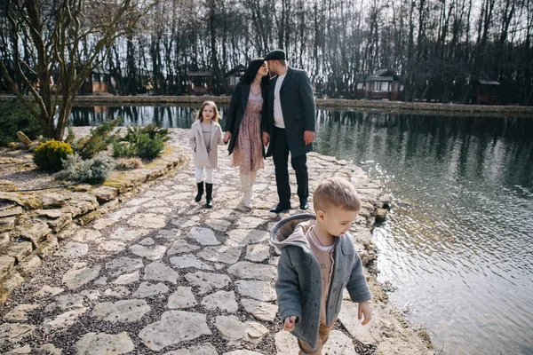 Feliz bela família se divertindo e andando junto ao lago no dia de outono . — Fotografia de Stock
