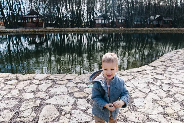 Хлопчик розважається і грає біля води. щаслива дитина біжить біля озера — стокове фото