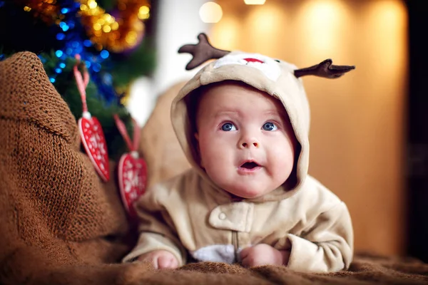 Bébé en costume de cerf à Noël. Bébé cerf, Enfant souriant en costume Image En Vente