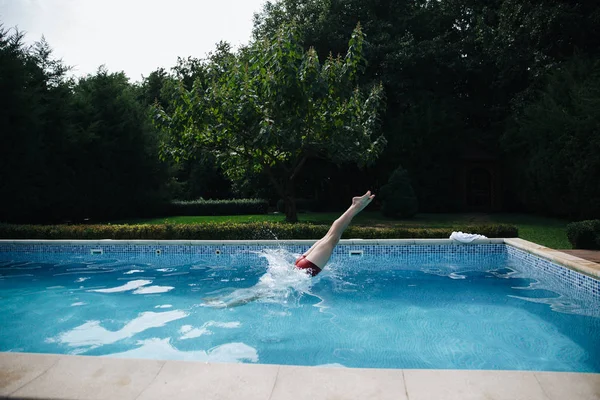 Fiatal férfi jumping a medencében, a kertben. az egészséges életmódhoz. Oldalnézet — Stock Fotó