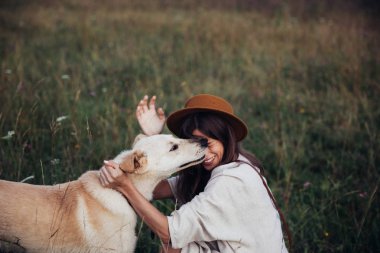 Güzel genç kadın rahat ve kaygısız onu güzel köpek ile bir yaz günbatımı zevk