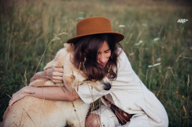 Güzel genç kadın rahat ve kaygısız onu güzel köpek ile bir yaz günbatımı zevk