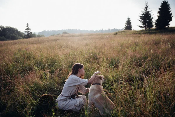 Fille et son chien ami jouent sur le fond de champ de paille. Belle jeune femme détendue et insouciante profitant d'un coucher de soleil d'été avec son beau chien — Photo