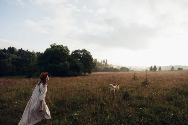 Woman enjoying nature and walking with golden labradore in meadow. Outstretched arms fresh morning air summer Field at sunrise. — Stock Photo, Image