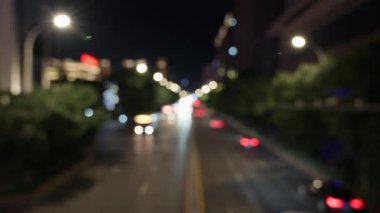 Bulanık ışıklarla şehir gecesi sahnesi.