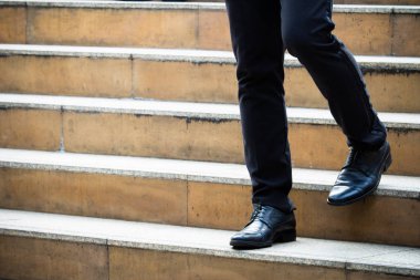 Şehirde merdivenlerden inerken adamın deri ayakkabılarını kapat.