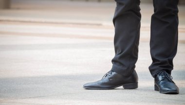 O ise ayakta ve bekleyen şehir adamın siyah deri ayakkabı yakın çekim.