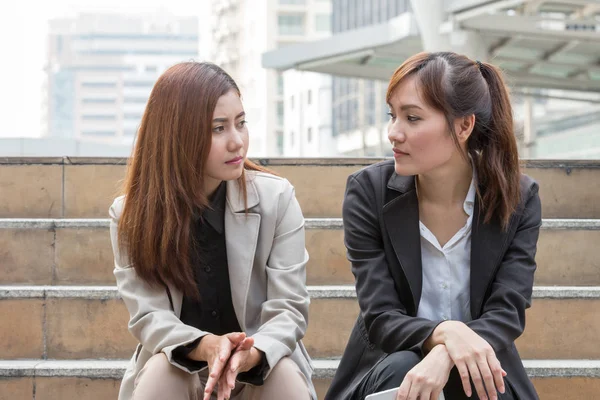 two business women are discussing and share about their work life. They have sympathy for each other