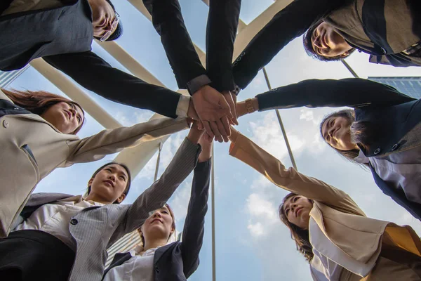 Team huddle of business people show the teamwork and unity. Group of employee is putting their hands together with on stack. Close up of hand stacked of salary man