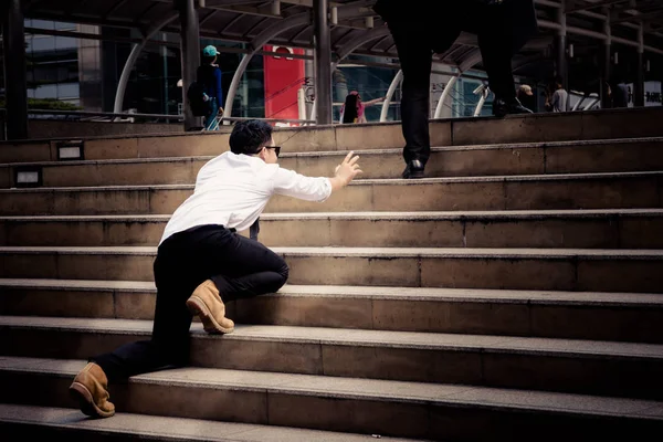 Competitor try to climb on the step to follow up smart Businessman who is walking on the steps and heading to his goal. Competition between big and small business.