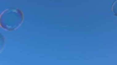 Soap bubbles against blue sky  lightness, joy, and childhood carefree mood for advertising, festive projects, backgrounds, wellness content, and summer campaigns