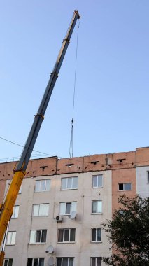 Construction crane in front of multi-story residential building on a sunny day  urban development, technical dynamics, and city infrastructure for architectural content, logistics projects